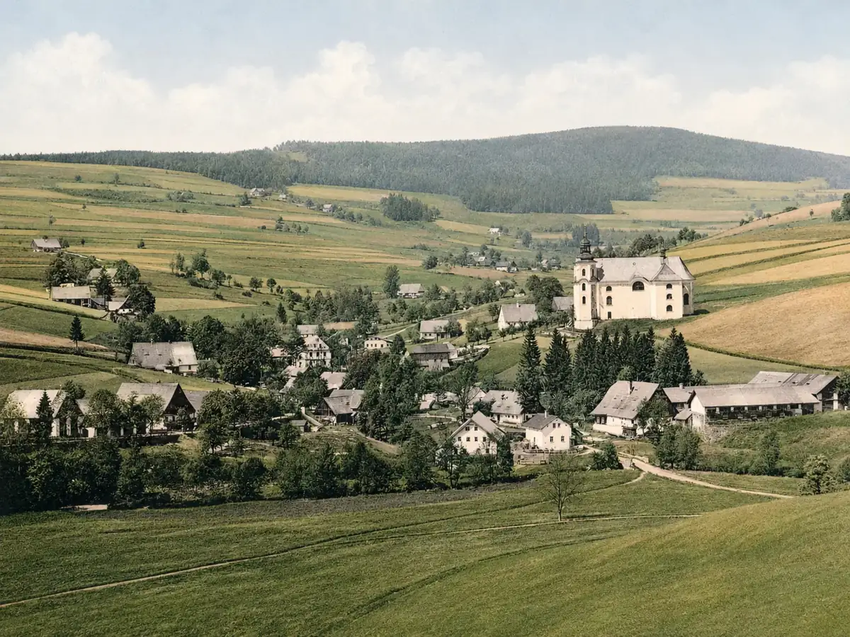 Údolí s kostelem a rozptýlenou zástavbou horské osady